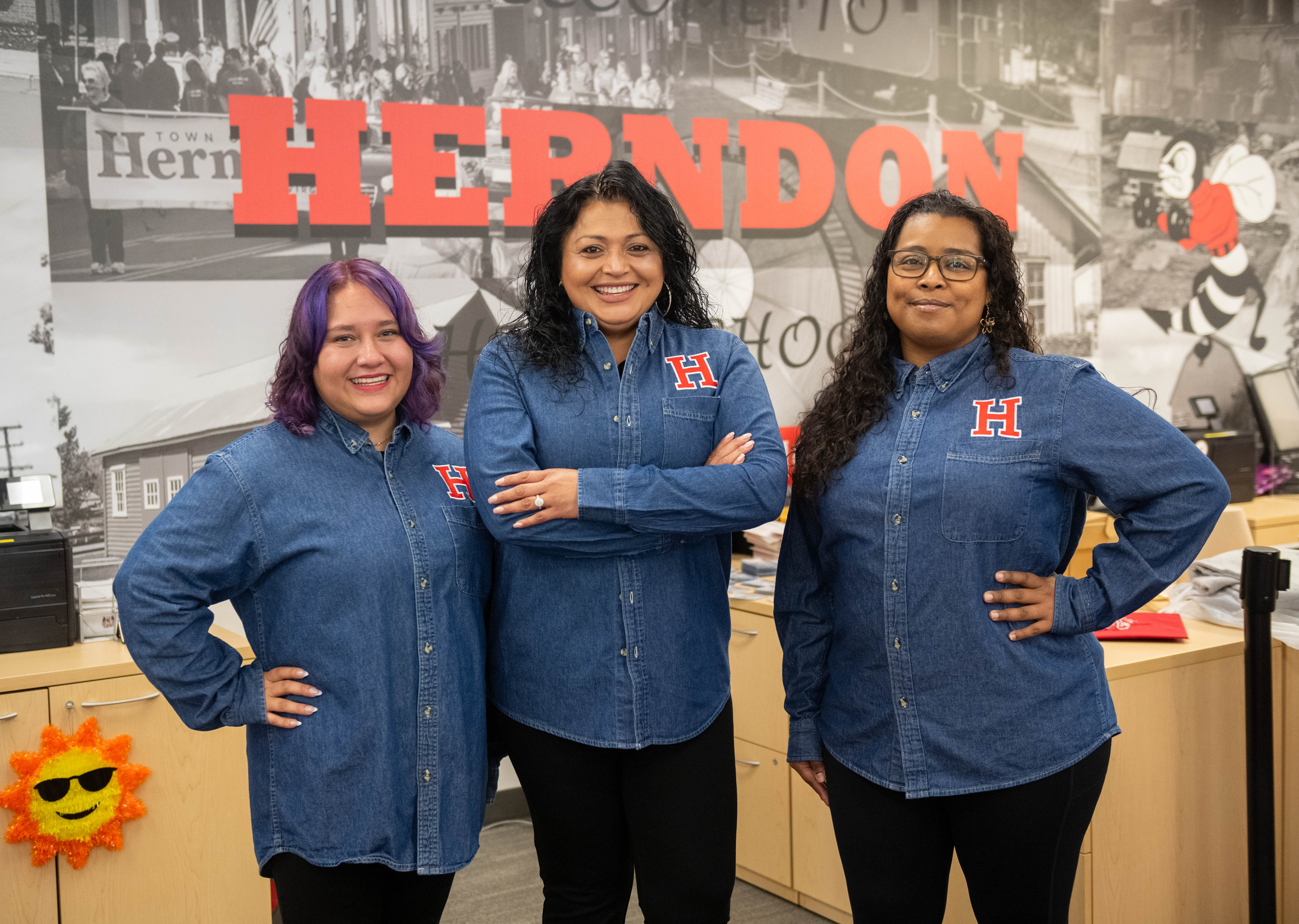 Isabel Silvestre, Fatima Mejia, and Beatrice Wiseman in front of Herndon Graphic in Herndon High School's front office